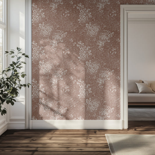 Hallway interior with brown and cream animal print wallpaper, plant, and sofa.