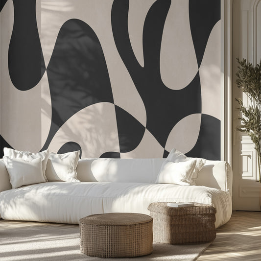 Modern living room with abstract black and white wall mural, white sofa, and wicker ottomans.