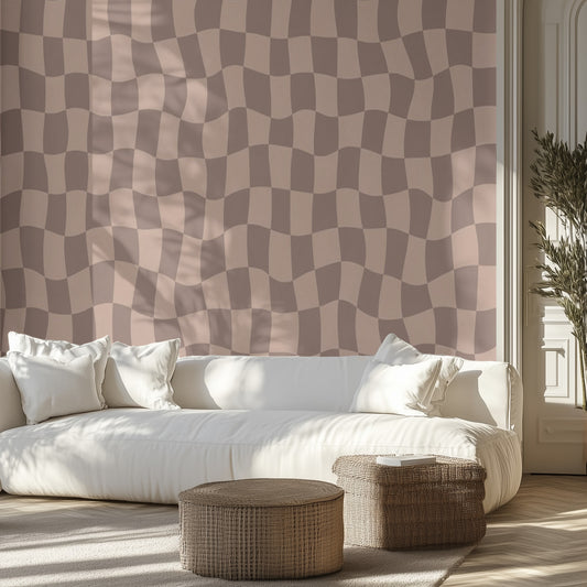 Living room with a white sofa, brown wavy checkered patterned wall mural, and wicker ottomans.