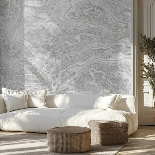Living room with a white sofa, patterned marble wall mural, and wicker ottomans.