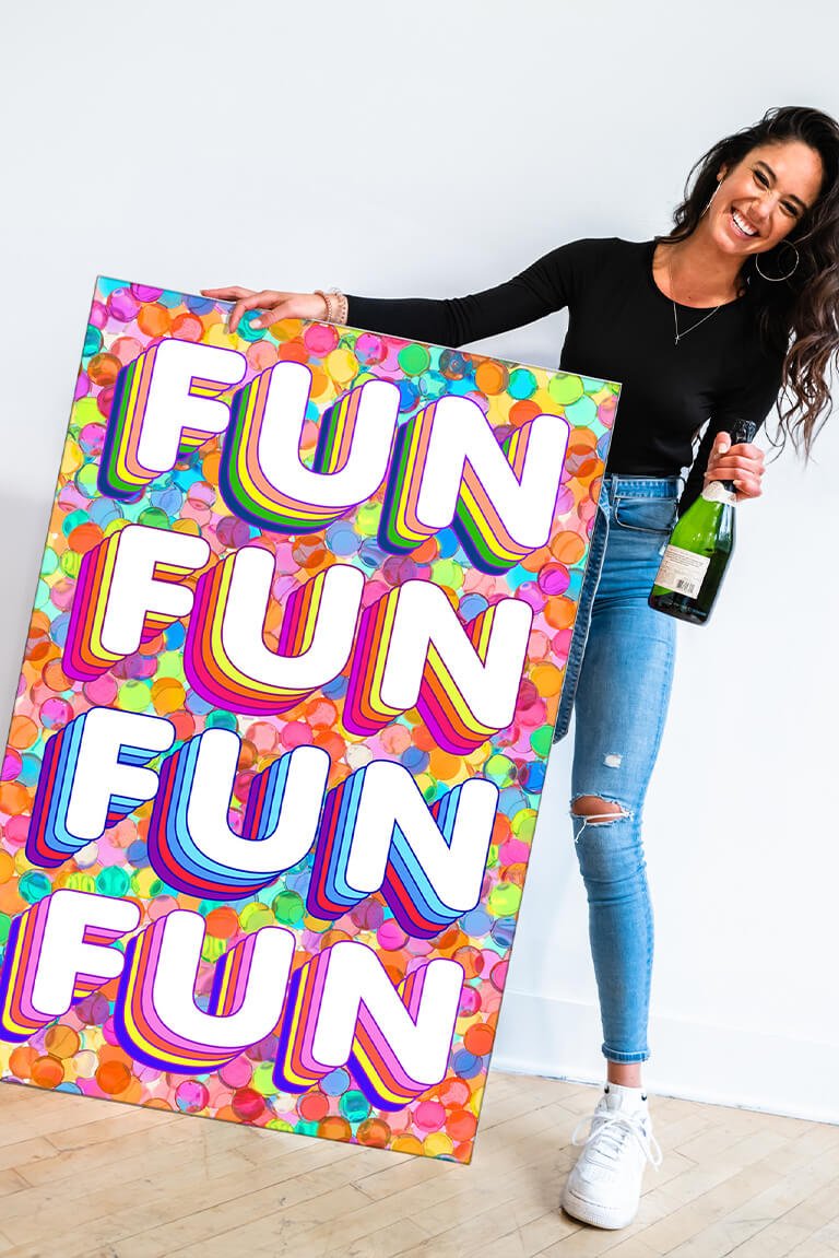 This vibrant and playful "Fun Fun Fun" print by Jessica Stempel. The maximalist wall art features a girl holding a champagne bottle in one hand and the colorful print in the other. The "FUN FUN FUN FUN" text is displayed in a retro bubble font with rainbow dots stamped in the background, creating a fun and playful vibe. This piece is perfect for adding a touch of personality to your maximalist bedroom and will bring a lively energy to your space.