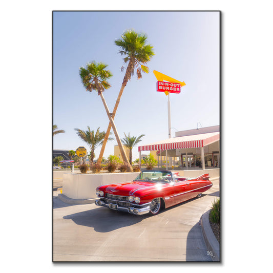 Vintage convertible parked in front of an In-N-Out Burger with palm trees and a clear blue sky.