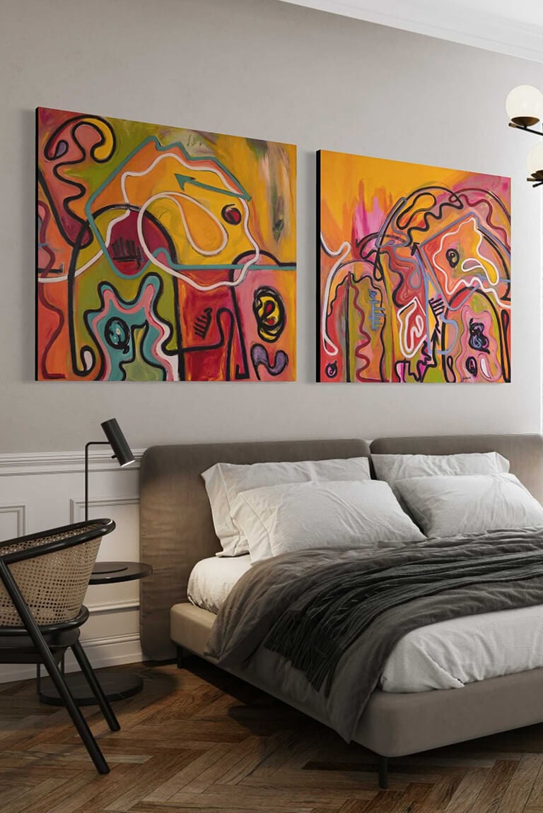 Two Large Warm Colorful Abstract Artworks Hanging Above A Bed