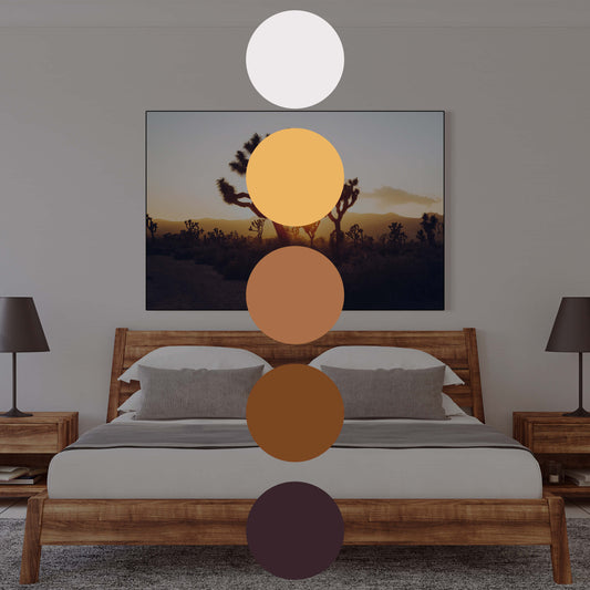 Landscape photo of Joshua Tree forest at sunrise hangs above the bed in neutral bedroom.