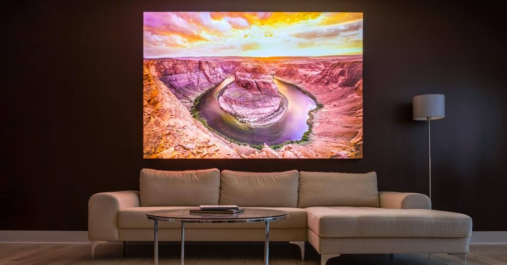 A living room with a cayon-river inspired backlit wall art hanging