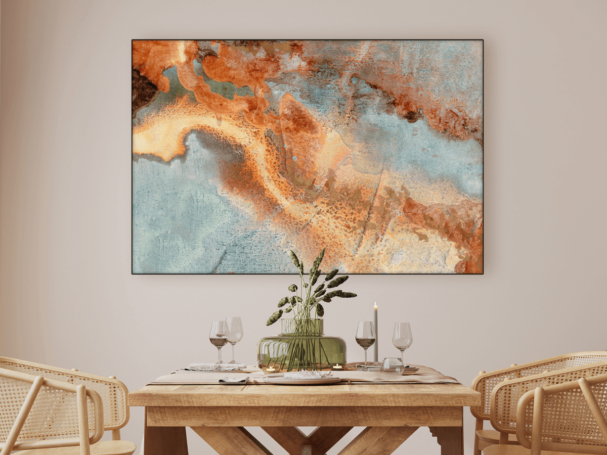 Scene of a dining area, all neutral and sort of warm colors with a beautiful abstract piece of artwork on the wall, tying the room together.