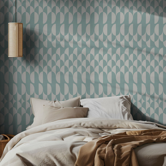 Bedroom with light teal, wavy geometric patterned wallpaper and soft bedding.