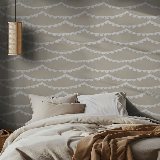 Bedroom with beige wallpaper with white scalloped garland and neutral soft bedding on the bed.