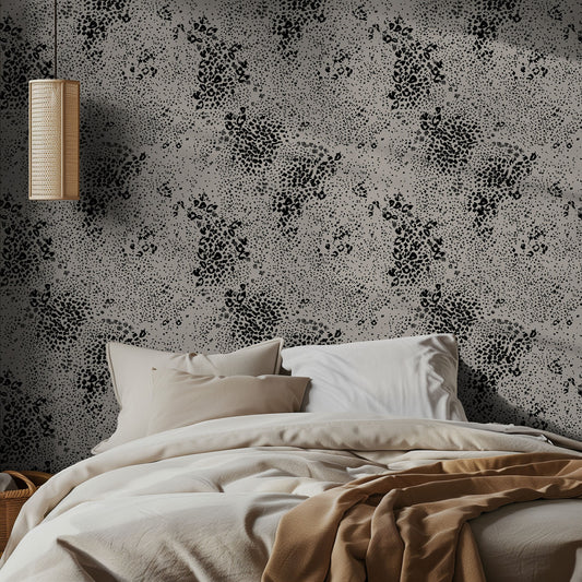 Bedroom with black and beige chetah patterned wallpaper and neutral bedding.