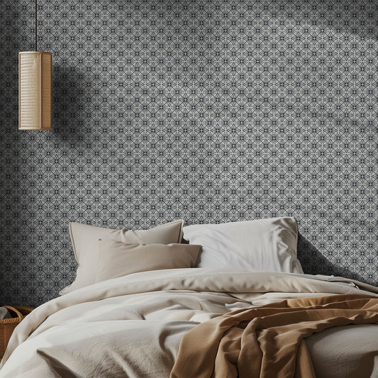 Bedroom with black and white geometric patterned wallpaper and neutral bedding