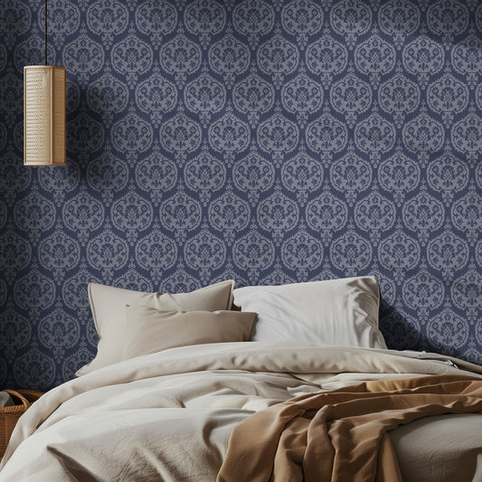 Bedroom with blue on blue damask wallpaper pattern and a bed with beige bedding.