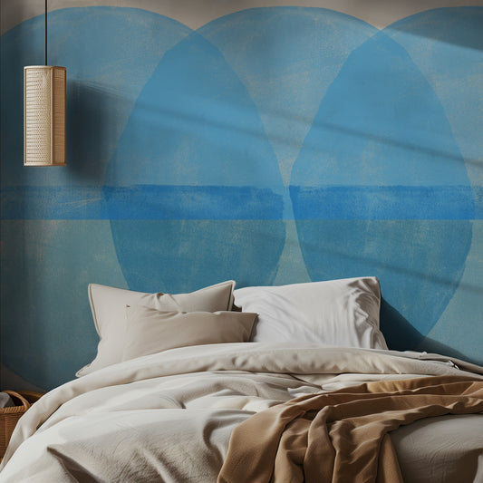 Bedroom with a large blue circular mural design on the wall and a wooden pendant light.