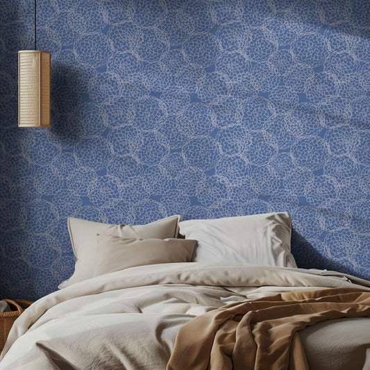 Bedroom with blue and white dahlia geometric wallpaper pattern, and beige bedding