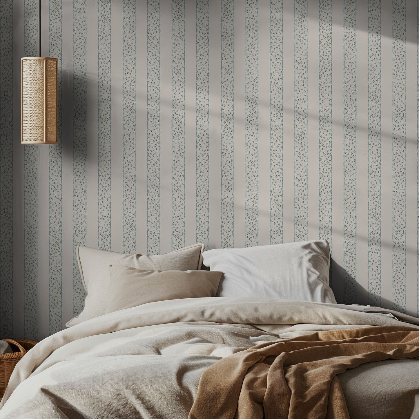 Bedroom with light striped wallpaper, neutral bed, and lamp.