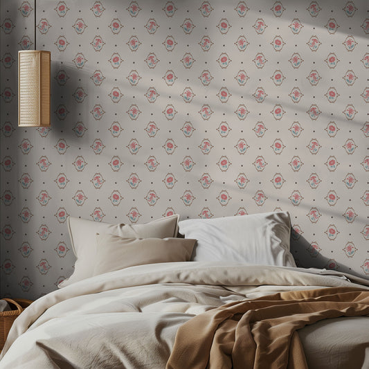 Neatly made bed with beige and brown bedding against a floral papered wall with a wall lamp.