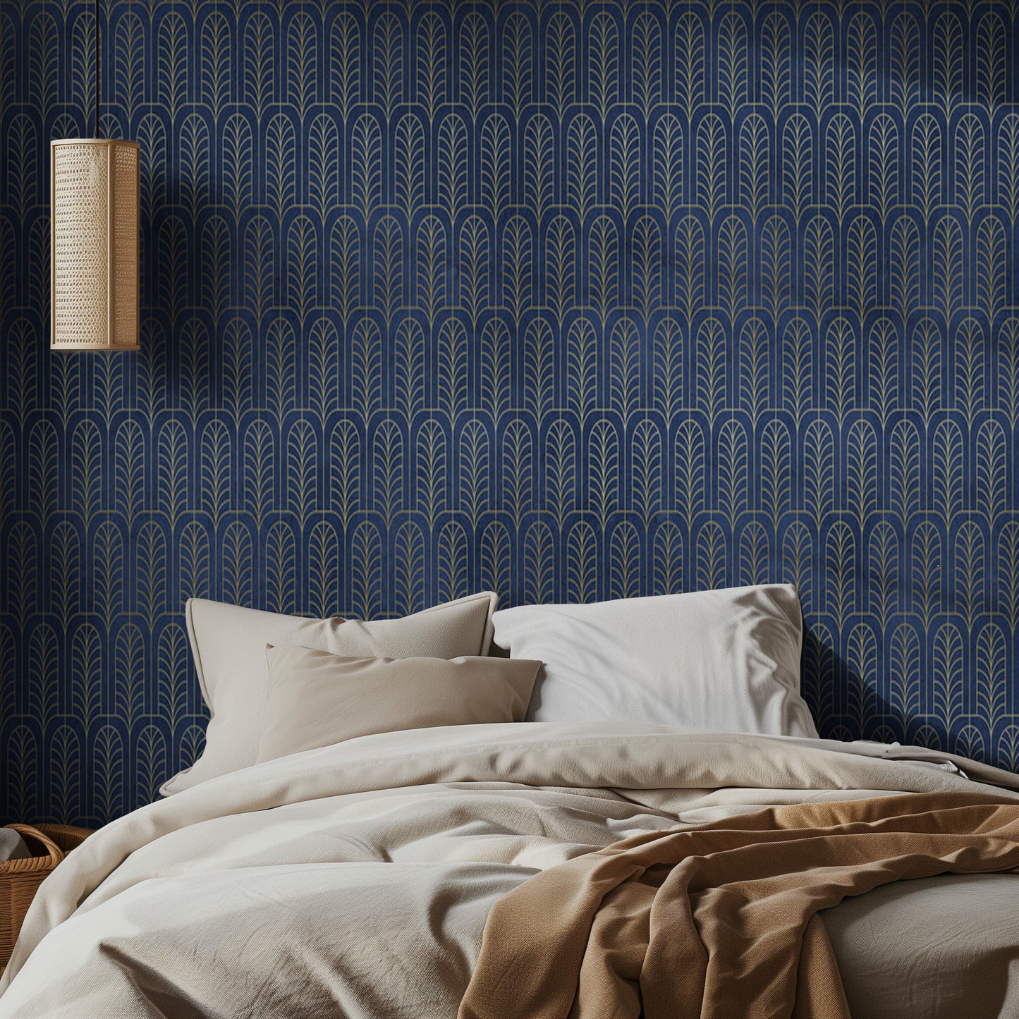 Bedroom with blue art deco patterned wallpaper, beige bedding, and a lamp.