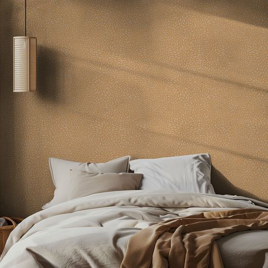 Bedroom with orange floral patterned wall, bed with pillows, and hanging light fixture.