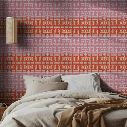Bedroom with a pink and red geometric patterned wall and soft bedding