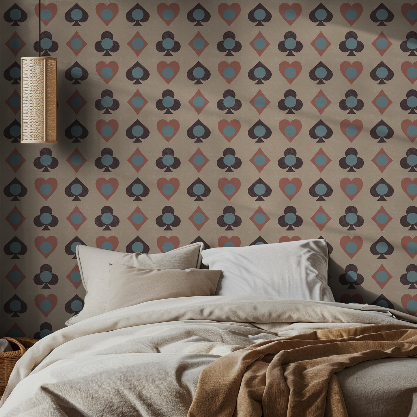 Bedroom with playing card patterned wallpaper featuring playing card suits and a bed with beige bedding.