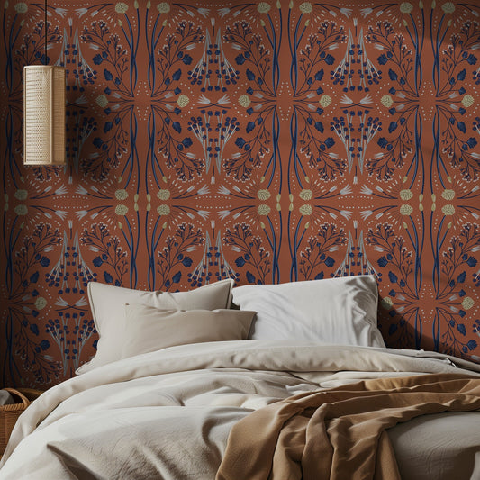 Bedroom with wallpaper in blue and yellow floral-pattern on terracotta and neutral bedding.