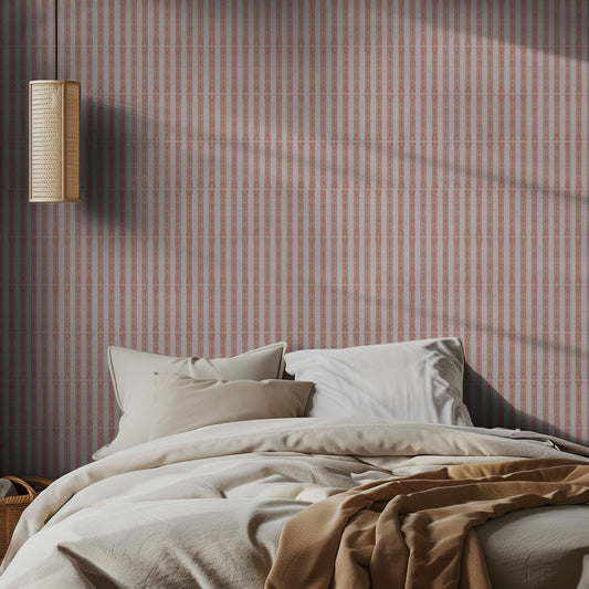 Bedroom with pink and white striped wallpaper, bed, and wall lamp.