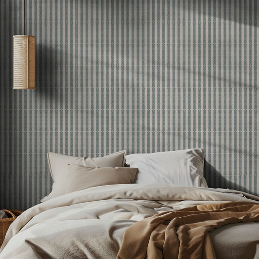 Bedroom with green striped wallpaper and a lamp on the wall.