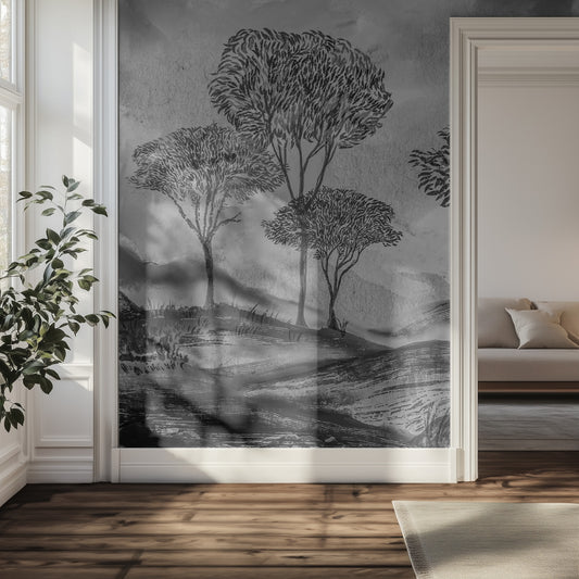 Room with a large wall mural of trees on a gray background, featuring a couch and plant.