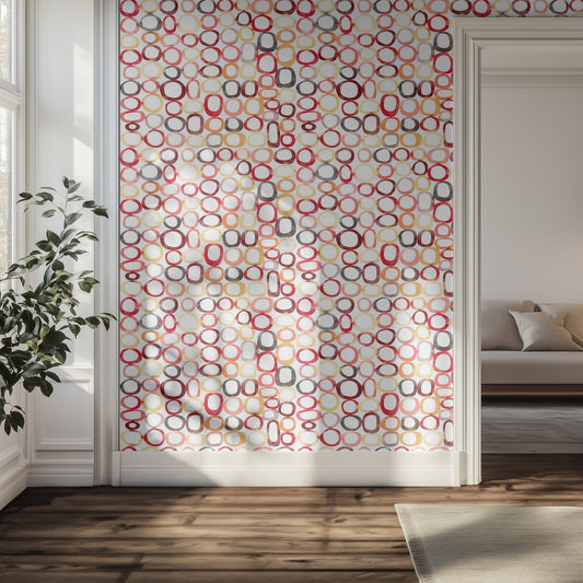 Hallway with watercolor ring pattern of reds, pinks, and yellows, wooden floor, and a plant.