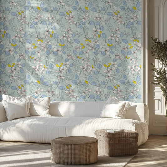 Living room with a white sofa, aqua white and blue patterned wallpaper, and wicker ottomans.