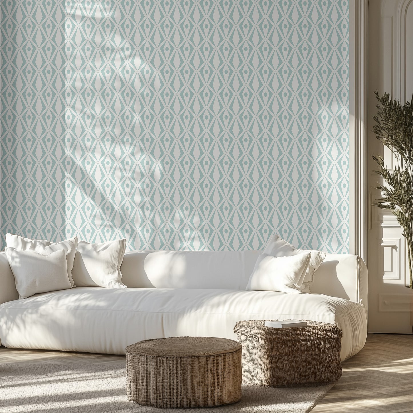 Living room with white sofa, white and aqua geometric patterned wallpaper, and wicker ottomans.