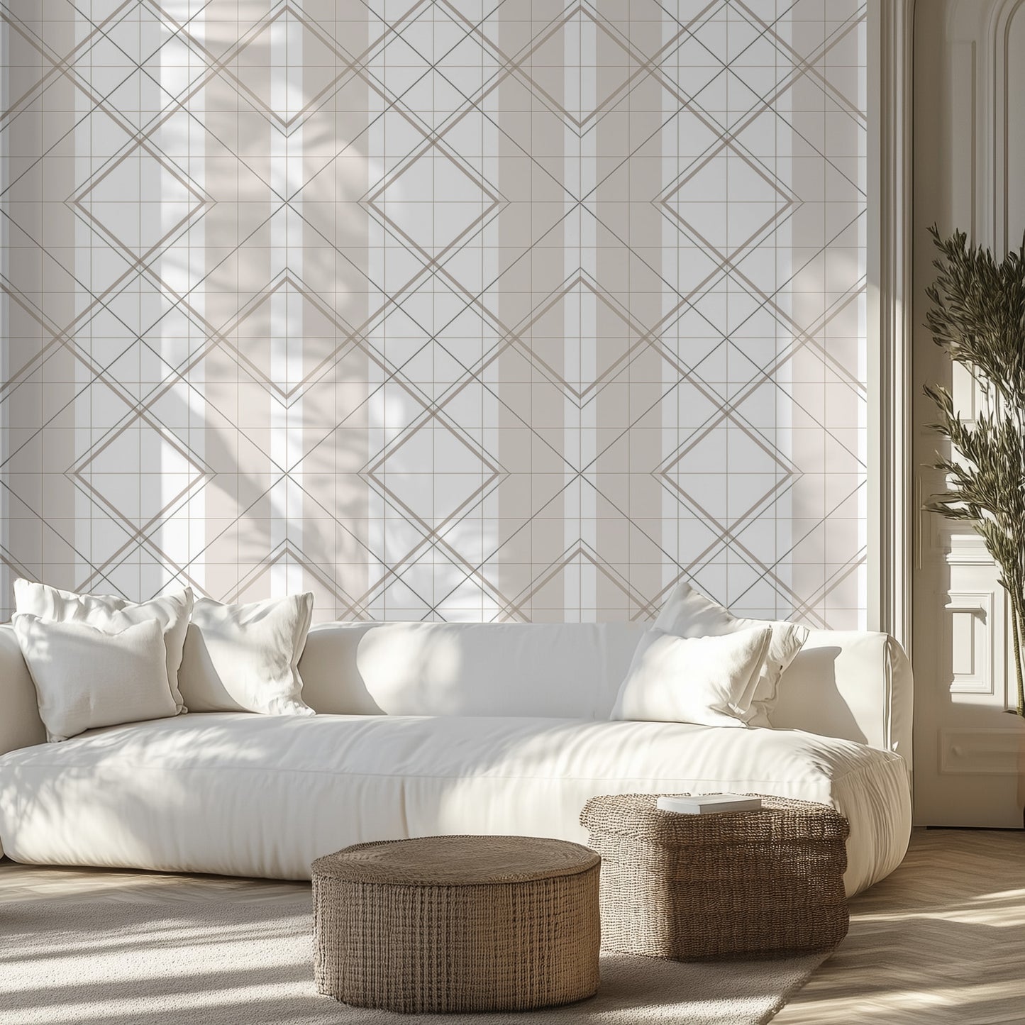 Modern living room with beige and white geometric wallpaper pattern, white couch, wicker ottomans.
