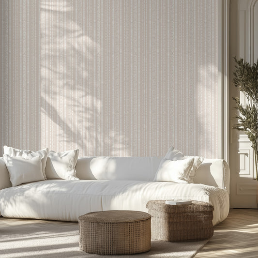 Light beige and cream dotted stripe wallpaper pattern in a modern living room with neutral white couch and two wicker ottomans.