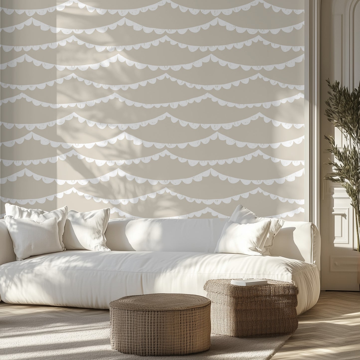 Modern living room with a white sofa, beige wallpaper with white scalloped garland, and wicker ottomans.
