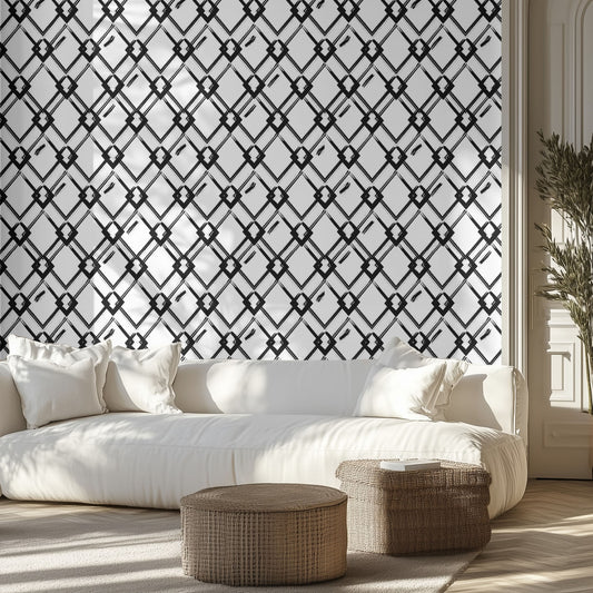 Living room with white sofa, blac and white diamond art deco wallpaper patterned wall, and wicker ottomans.