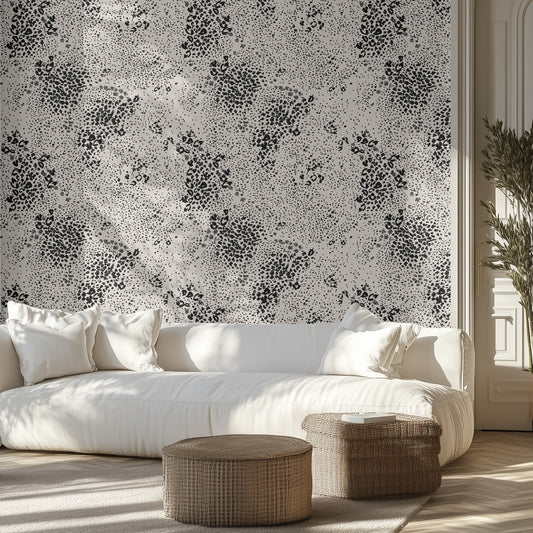 Modern living room with white sofa, black and gray chetah patterned wall, and wicker ottomans.