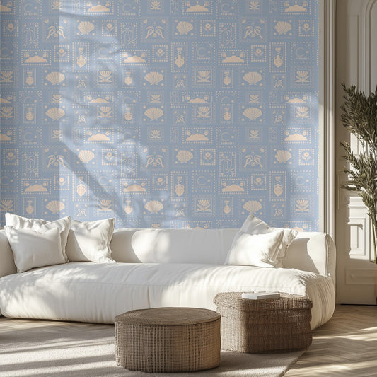 Living room with a white sofa, vintage postage stamp patterned wallpaper, and wicker ottomans.