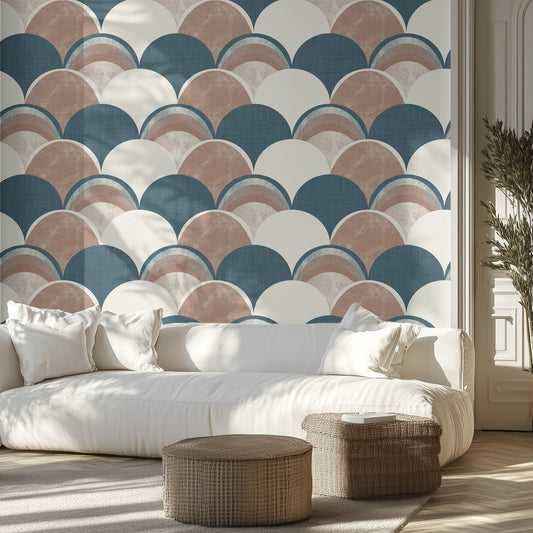 Living room with a blue and brown, textured wallpaper patterned wall, white sofa, and wicker ottomans.