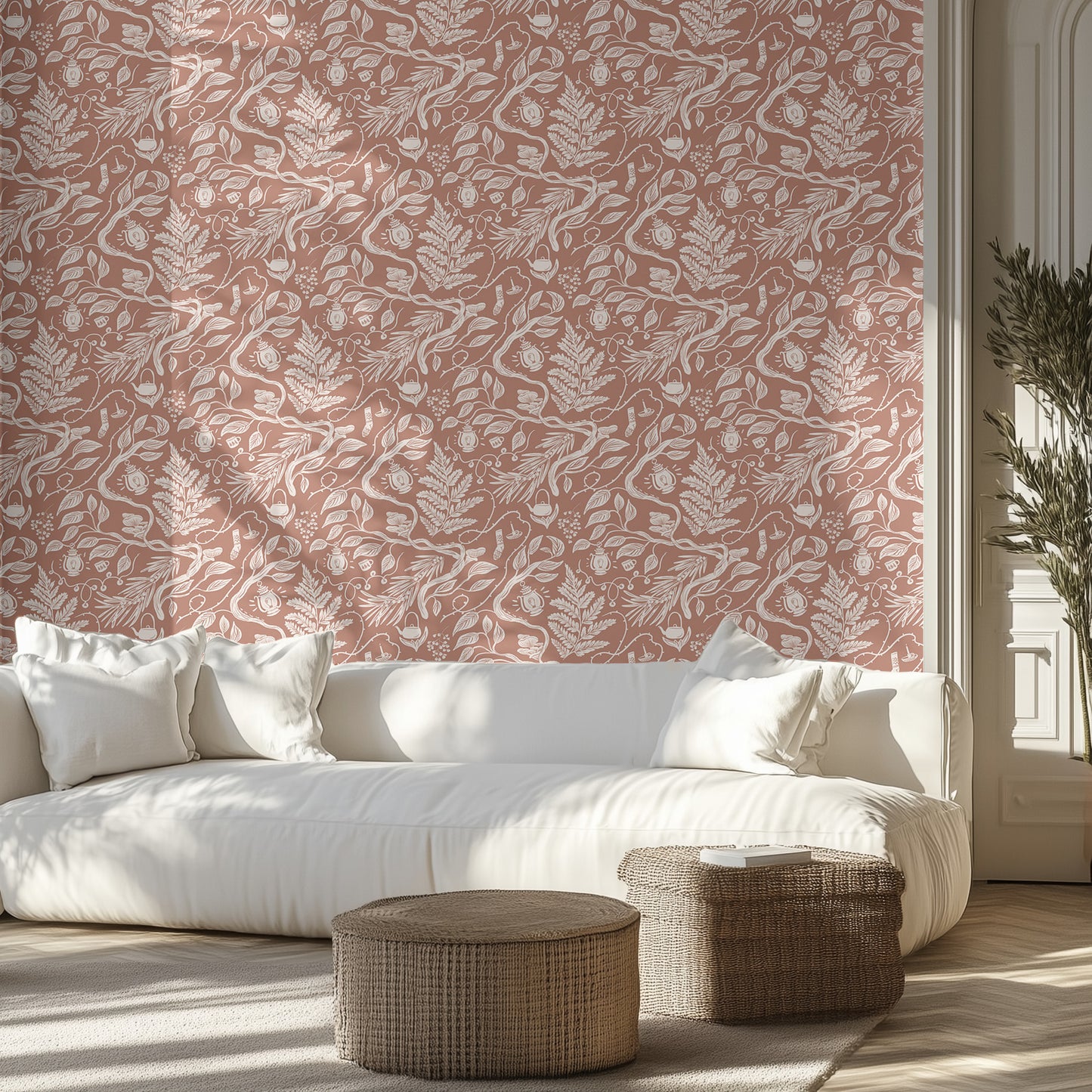 Living room with white sofa, brown and white boho foliage patterned wall, and wicker ottomans.