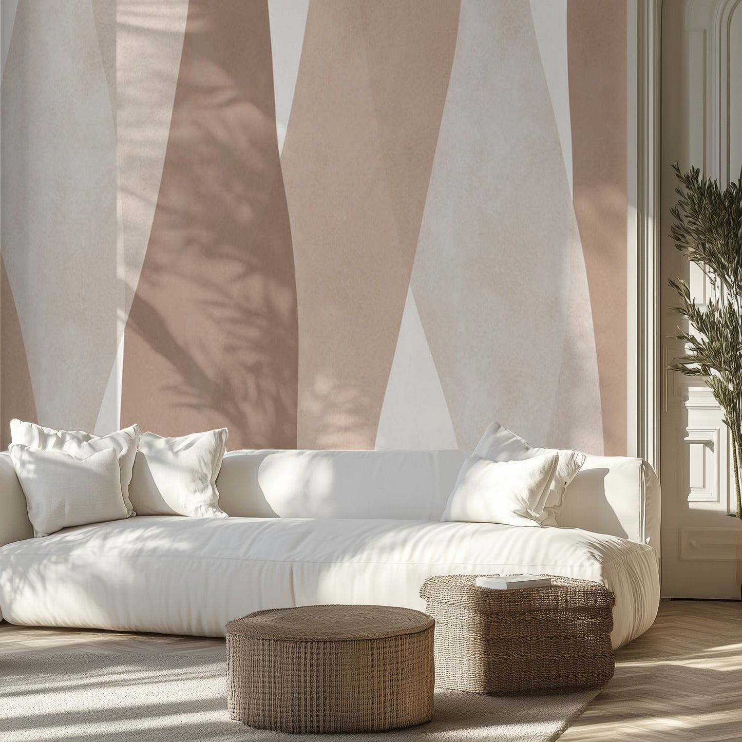 White sofa with white pillows in a room with a neutral watercolor wall mural.