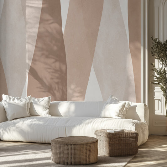 White sofa with white pillows in a room with a neutral watercolor wall mural.
