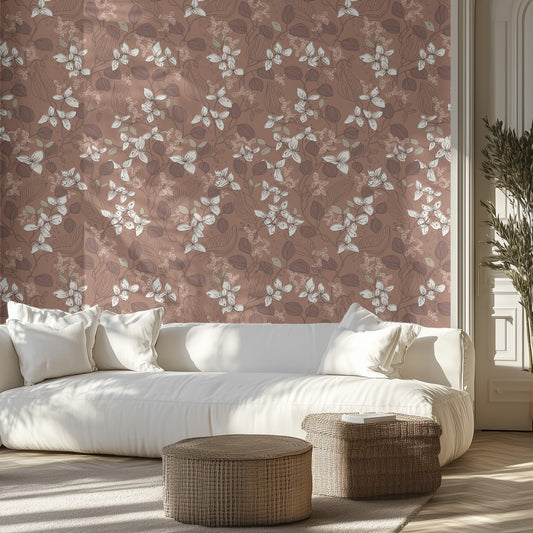 Living room with brown, boho floral wallpaper, white sofa, and wicker ottomans.