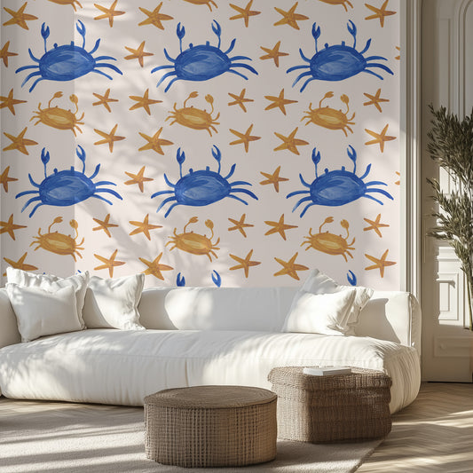 Living room with a white sofa, wicker ottomans, and a wall featuring blue and yellow crab and starfish wallpaper pattern.