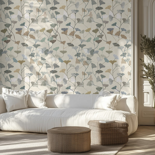 Living room with neutral leaf and floral wallpaper, white sofa, and wicker ottomans.
