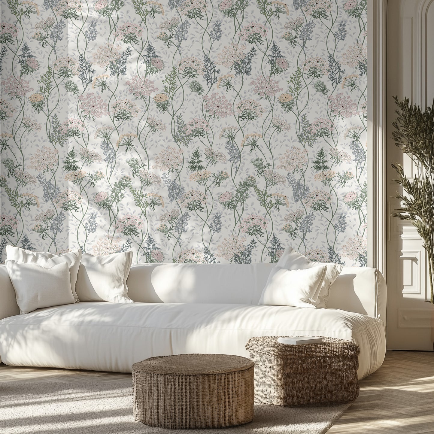 Living room with light floral wallpaper, white sofa, and wicker ottomans.