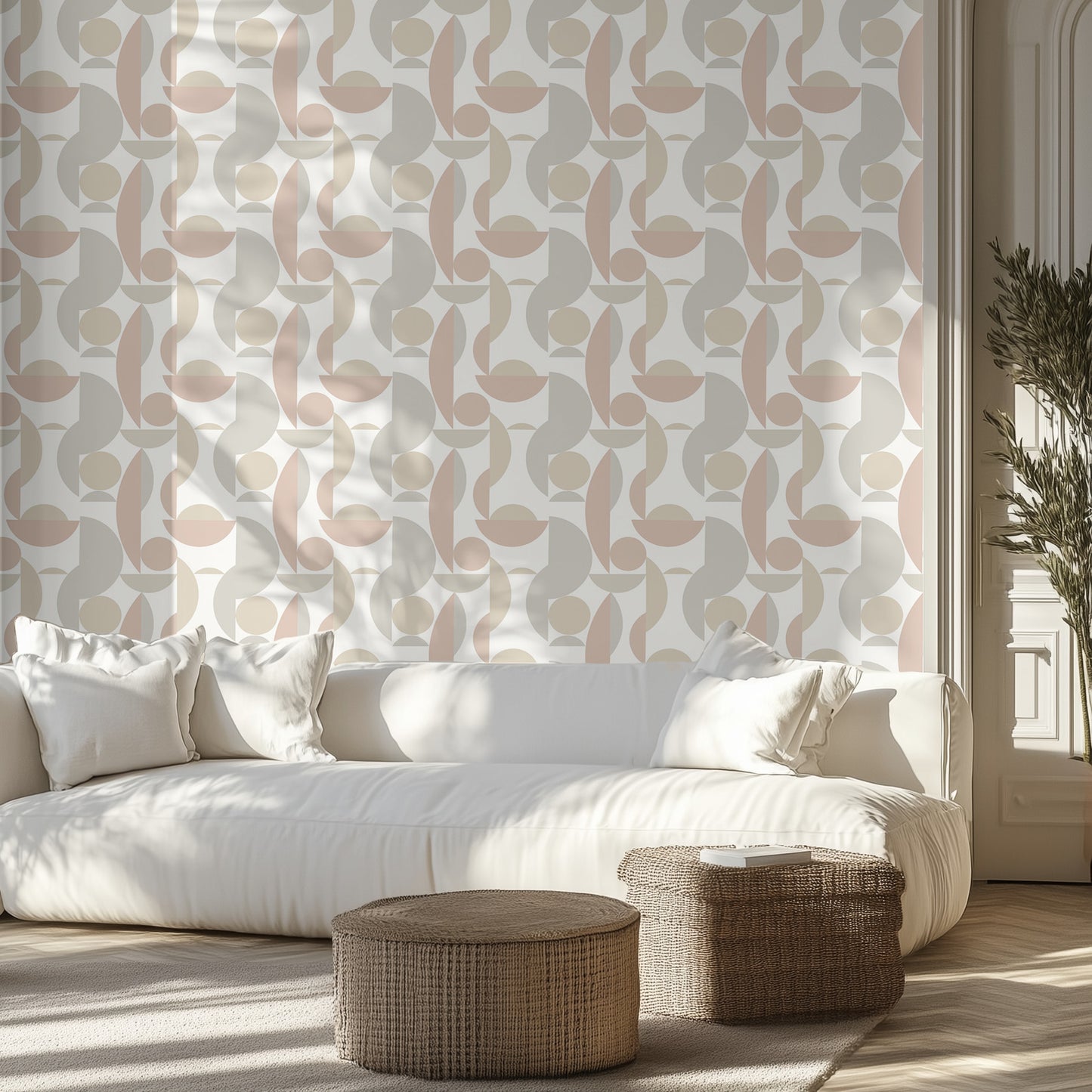 White sofa with decorative pillows in a room with a soft, neutral geometric wallpaper pattern and wooden floor.