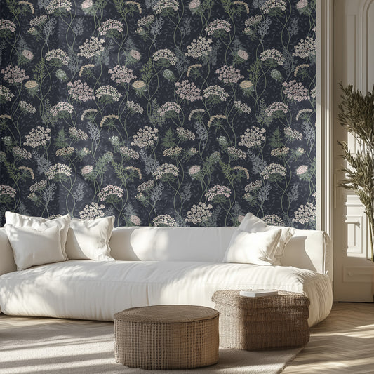 Living room with dark blue floral wallpaper, white sofa, and wicker ottomans.