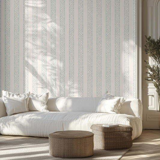 Living room with white sofa, white and blue patterned wallpaper, and wicker ottomans.