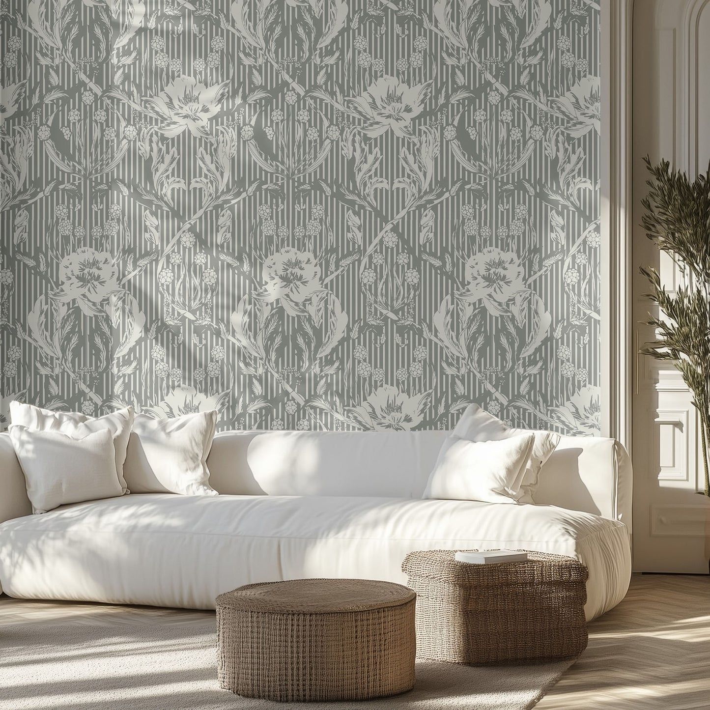 Living room with a white sofa, forest green and cream floral patterned wallpaper, and wicker ottomans.