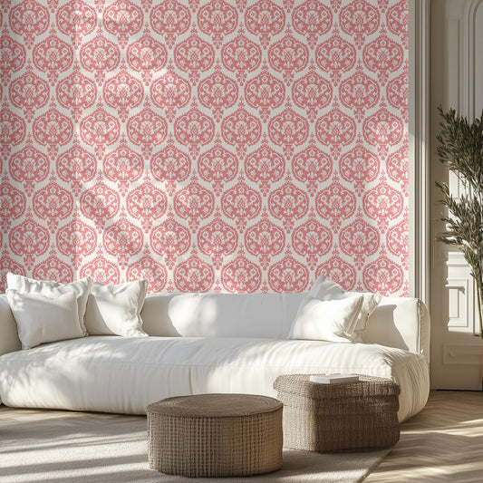 Living room with white sofa, pink and white damask wallpaper on the wall, and wicker ottomans.