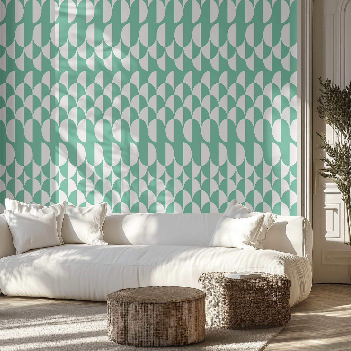 Living room with a white sofa, wicker ottomans, with teal and white geometric wallpaper.